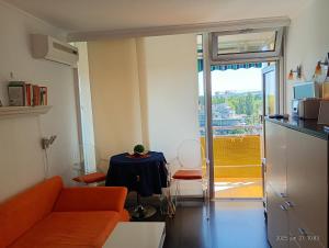 a living room with a couch and a table and a window at Neptun Residence in Balatonföldvár