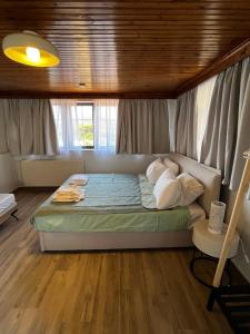 a bedroom with a large bed with a wooden ceiling at Blue Olive House & Studio in Artemida