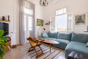 a living room with a blue couch and a table at Charming 2 BR Apt By The Foot Of The Bahai Temple in Haifa