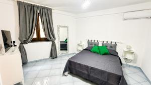 een slaapkamer met een bed met een groen kussen bij Suite Green & Orange - Casa Santicelli in Maratea