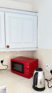 a red microwave sitting on top of a kitchen counter at Edinburgh City Centre Flat in Edinburgh