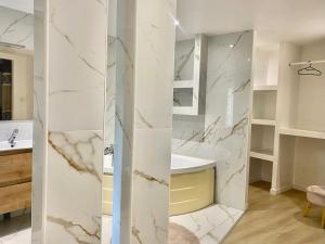a bathroom with white marble walls and a sink at Chambres d'hôtes - La correziene in Allassac +29 photos