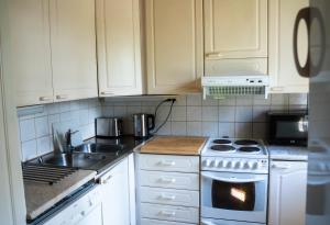 a kitchen with white cabinets and a sink and a stove at Villa Christmas Star Private Sauna By Lapland Host in Rovaniemi