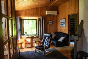 a living room with a chair and a couch at Villa Christmas Star Private Sauna By Lapland Host in Rovaniemi