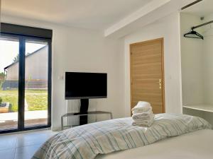 a bedroom with a bed with a television and a window at Chambres d'hôtes - La correziene in Allassac