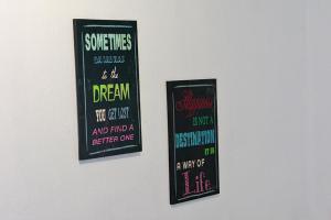 two signs hanging on a wall with writing on them at Chic 2BR Apartment in Roodepoort in Roodepoort