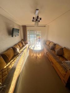 a living room with two large couches and a television at Apparemment saidia ap13 in Saidia 