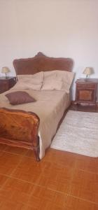 a bedroom with a wooden bed with two night stands at Cantinho Alentejano-Rua das Hortas, Corte Pao e Agua in Mértola