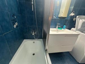 ein Badezimmer mit einer weißen Badewanne und einem Waschbecken in der Unterkunft Beachfront apartment in Sant Salvador