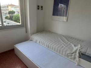 ein Bett in einem Zimmer mit einem Fenster in der Unterkunft Beachfront apartment in Sant Salvador