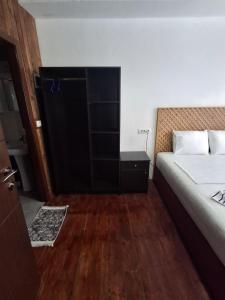 a bedroom with a bed and a dresser and a bed sidx sidx at MiziriGuestHouse in Gjirokastër