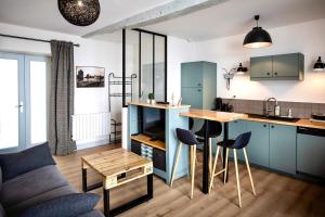 a kitchen with blue cabinets and a table and chairs at Le Maréchal - Coeur de ville in La Rochelle