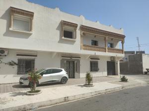 RejicheMaison Rejiche Mahdia的一辆白色汽车停在一栋建筑物前