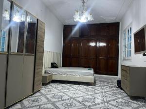 a bedroom with a bed and a chandelier at MAHDIA REJICHE MAISON AVEC PISCINE privee in Rejiche