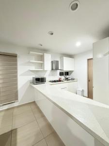 a white kitchen with white cabinets and a counter at Almarena Residencial in Mazatlán