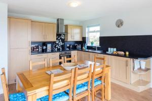 a kitchen with a wooden table and some chairs at Sunrise in Saint Columb Major