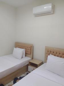 a bedroom with two beds and a air conditioner at شقه فندقيه in Sheikh Zayed