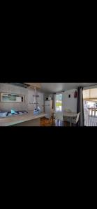 a kitchen with white cabinets and a table and a dining room at Mobilhome in Ivry-la-Bataille