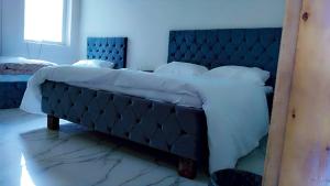 a large bed in a bedroom with a blue wall at Junction Resort 