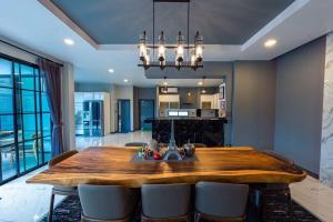 Un comedor con mesa y sillas de madera. en BoomVilla 2, en Pattaya South