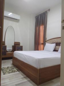a bedroom with a bed and a mirror at شقه فندقيه in Sheikh Zayed