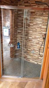 a shower in a room with a stone wall at Oasis rural in Benidorm in Benidorm