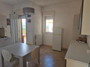 cocina con mesa blanca y nevera blanca en Casa Egle - Between Etna and the sea, en Giarre 24 fotos más