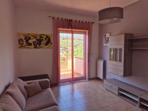 Una sala de estar con un sofá y una puerta corrediza de vidrio. en Casa Egle - Between Etna and the sea, en Giarre