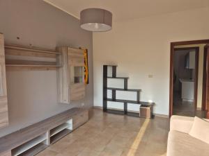 Una sala de estar con un sofá y una escalera. en Casa Egle - Between Etna and the sea, en Giarre