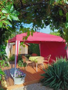 迪森阿姆阿梅尔塞Ferienwohnung Dießen Bierdorf EG的一个红色的帐篷，甲板上有一张桌子和椅子