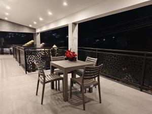 Una mesa y sillas en el balcón de una casa. en RR Holiday Grand, en Kodaikanal