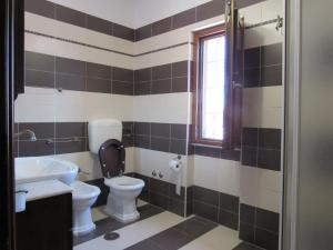 a bathroom with a sink and a toilet and a window at Villa Lemy in Cerasella +25 photos