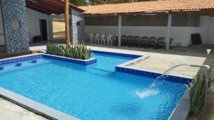 a swimming pool with a water fountain at Chácara Sol e Lua in Pau dos Ferros