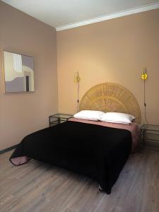 una camera da letto con un grande letto con una coperta nera di Aqui Há Gato a Vila Praia de Âncora