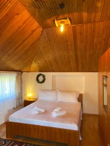 a bedroom with a bed with two towels on it at Guesthouse Hoxholli in Gramsh