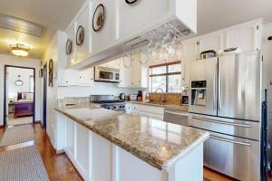 Una cocina con gabinetes blancos y electrodomésticos de acero inoxidable. en Lazy Bear Cabin ~ Dog-friendly home with private hot tub, ping-pong, basketball & firepit, en Big Bear Lake 16 fotos más