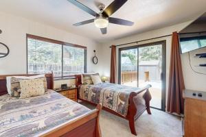 Un dormitorio con dos camas y un ventilador de techo. en Lazy Bear Cabin ~ Dog-friendly home with private hot tub, ping-pong, basketball & firepit, en Big Bear Lake