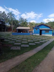 a large grass field with a building in the background at Recanto Paraíso in Rio Piracicaba