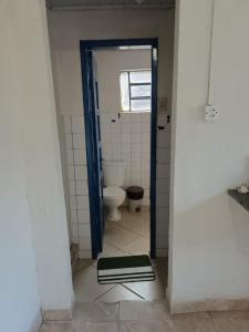 a bathroom with a toilet and a door open at Recanto Paraíso in Rio Piracicaba +6 photos