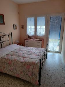 a bedroom with a bed and two windows at Bianca Marea in Realmonte