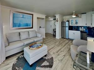 a living room with a white couch and a kitchen at Wake Up to Waves Lovers Key - 1 BR Escape With Private Beach in Fort Myers Beach