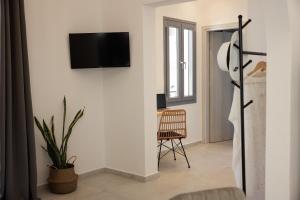 a living room with a tv on a wall at CasaNova Luxury Apartment in Naxos Chora