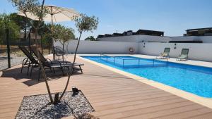 a pool with a chair and a tree next to it at Refúgio da Barragem in Vale de Anta