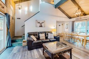 a living room with a leather couch and a table at Moose-in' Around ~ Walk to Slopes Mountain Home with Private Hot Tub, Ski Locker & Playground in Big Bear Lake