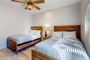 Un dormitorio con dos camas y un ventilador de techo. en Hillside Hideaway ~ Dog-friendly home with wraparound deck, grill, game room, & bar - walk to dining, en Big Bear Lake
