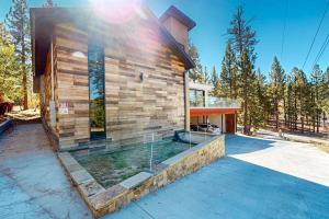 una casa de madera con piscina frente a ella en Hillside Hideaway ~ Dog-friendly home with wraparound deck, grill, game room, & bar - walk to dining, en Big Bear Lake