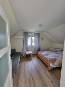 a bedroom with a bed and a couch and a window at Dom całoroczny Trzyakacje in Rydzewo