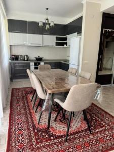 a kitchen with a wooden table and chairs on a rug at Baytur-Yilla09 in Bosteri +7 photos