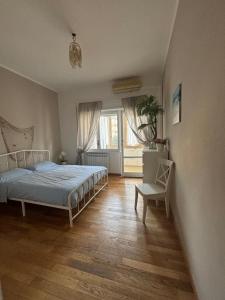 een slaapkamer met een bed en een houten vloer bij il gioiello del mare in Lido di Ostia