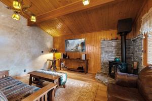 Una sala de estar con chimenea de piedra y un sofá. en Craftsman Hideaway ~ Cabin near the lake and zoo with fireplace, full kitchen, patio, & BBQ, en Big Bear Lake